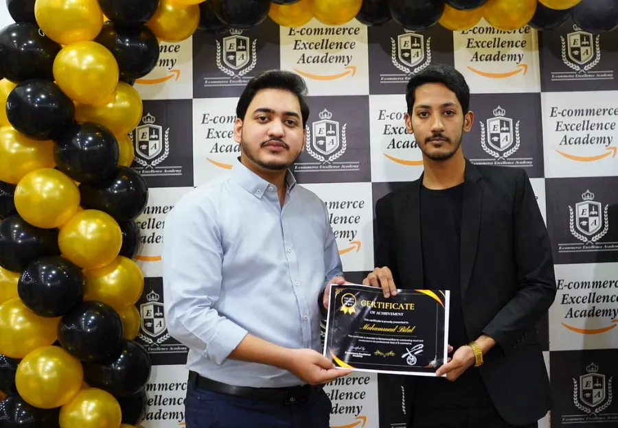Two students holding a Certificate of Achievement at E-Commerce Excellence Academy Karachi
